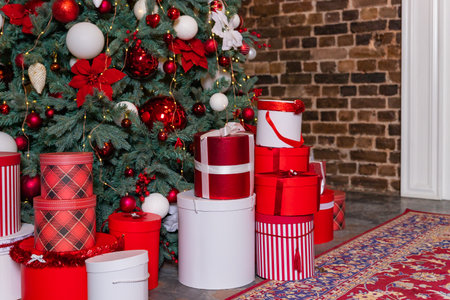 Multicolored gifts under the Christmas tree photo close-up New Years Eve, multicolored gifts, red and white.Interior of festive living room with gift boxes under Christmas treeの写真素材