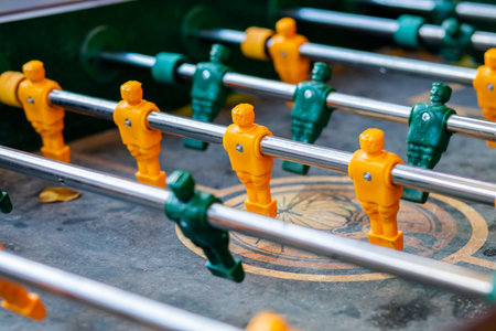 sports bar room, colleagues teammates play table football, game in the office, having fun, tabletop...