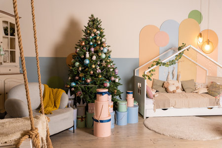 Interior of living room with Christmas New year decor,light garland and Christmas tree with presents under it.Festive mood. A surprise for family and friends.Big pink and blue boxesの写真素材