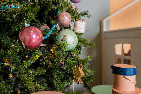 Christmas background. Family holiday.Multicolored Christmas tree decorations, tree with garlands and glass balls. Winter holidays decor. Blue, gold, pink baubles are hanging on branches.の写真素材