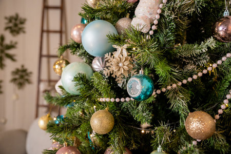 Christmas background. Family holiday.Multicolored Christmas tree decorations, tree with garlands and glass balls. Winter holidays decor. Blue, gold, pink baubles are hanging on branches.の写真素材