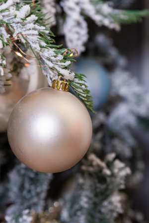 Elegant Christmas tree with white and pink toys in the living room of luxury apartments.Decorative Christmas tree adorned with snow-like frosted branches and a variety of ornamental balls.の写真素材