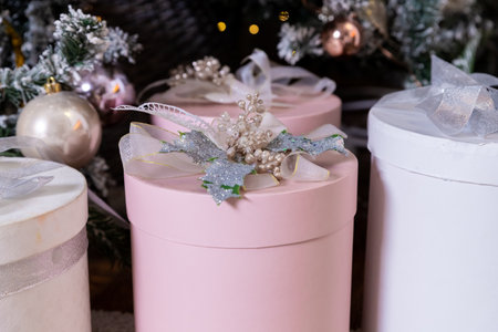 Stylish bright interior of living room with beautiful fluffy Christmas tree and gifts under it in gray and pink, Christmas and New Year celebration. Winter holidays surpriseの写真素材