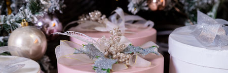 Stylish bright interior of living room with beautiful fluffy Christmas tree and gifts under it in gray and pink, Christmas and New Year celebration. Winter holidays surpriseの写真素材