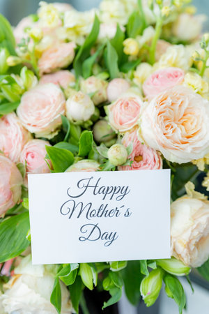 Happy Mothers Day greeting label and beautiful flowers.Close up of a beautiful bouquet of roses with a happy mothers day card.event design concept.Big bunch of fresh pink rosesの写真素材