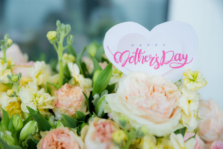 Happy Mothers Day greeting label and beautiful flowers. Close up of a beautiful bouquet of roses with a happy mothers day card. event design concept. Big bunch of fresh pink rosesの写真素材