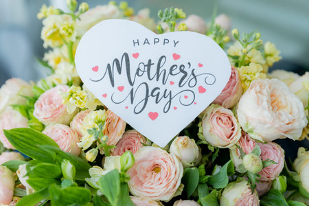 Amazing tender bouquet with pink ranunculus, violet Alstroemeria flowers and tiny white roses in cardboard box with pink ribbon. Beautiful bunch of spring flowers.の写真素材