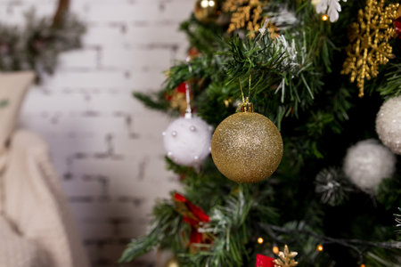 A golden and white ornament hangs on a Christmas tree. the ornaments are hanging from the branches. winter holidays,snowflake, beautiful decoration for home.Christmas decorationsの写真素材