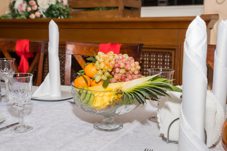 Banquet table served with fruits in the vase. Various fruits on the festive table. Grapes and kiwi.Beautiful giving of fruit at restaurant for a holidayの写真素材