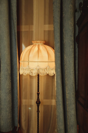 beautiful Lampshade in bedroom.old floor lamp with a hole with a fringe.Room decoration in retro style, furniture details and old lamps by the window.Vintage floor lampの写真素材