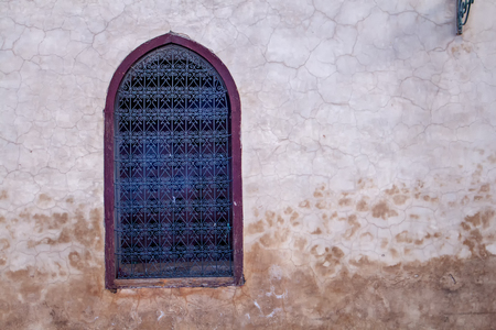 Old wall with a window with ornamental grating. Contrast frame around the window.の写真素材