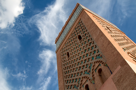 Tower of a famous mosque in medina of Marrakesh. Traditional details of the arabian architecture. Cloudy sky.の写真素材