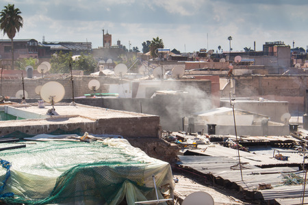 View from a roof on the old city - medina of Marrakesh. Small residential houses. Cloudy sky.のeditorial素材