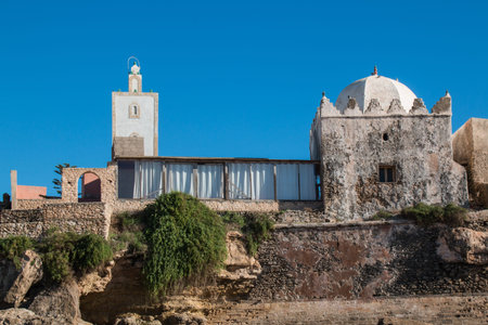 Small mosque in the village on the coast of Atlantic Ocean in Morocco, Moulay Bouzerktoun. Bright blue sky.の写真素材