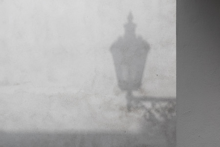 Monochromatic version of a grey wall with a shadow of a traditional lantern.の写真素材
