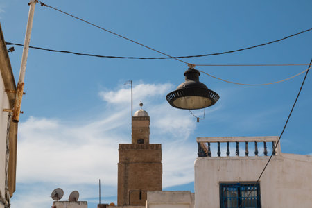 Street lamp hanging on the cables between the houses. Traditional architecture and minaret of a...