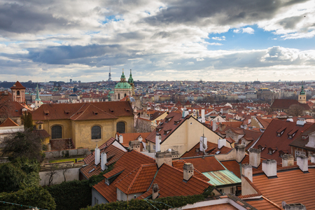 View on the roofs of the buildings in the old city, with its towers of the churches. Intense clouds on the blue sky. Prague, Czech republic.の写真素材