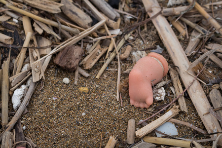 Leg of a doll forgotten or lost on the beach among the various trash. Part of the set Beach discoveries. Crete, Greece.の写真素材