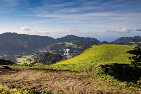 Nature with green fields, meadows and forests, located in a valley, surrounded by mountains. Blue...