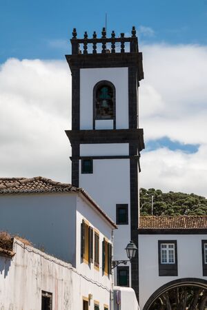 Characteristic tower of the City hall, with white facade and square shape. Belfry in the upper part. Blue sky. Ribeira Grande, Sao Miguel, Azores Islands, Portugal.の写真素材