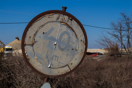Old weathered and rusted traffic sign with a speed limitation forty km per hour. Nature with trees...