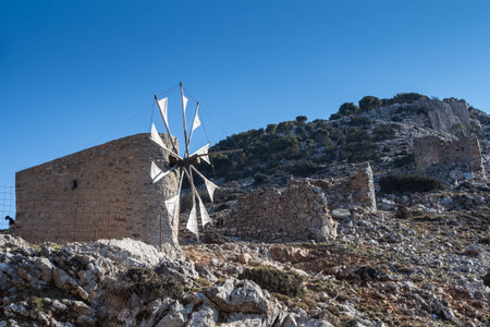 Windmills made of stone, located on a hill in Pinakaino, Lasithi Plateau. Bright blue sky. Crete, Greece.の写真素材