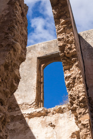 Broken walls and roof of a ruin of an abandoned house. View from inside of the building. Broken...