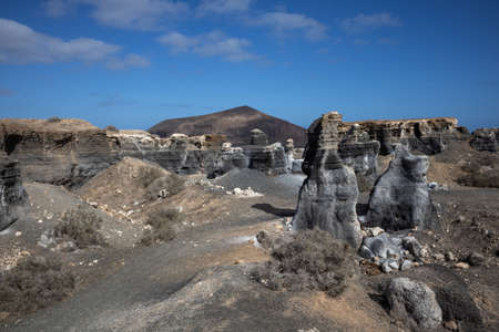 Vulcanic soil and objects, which are similar to statues, created by the nature. Blue sky with white clouds in the spring. Lanzarote, Canary Islands, Spain.の写真素材