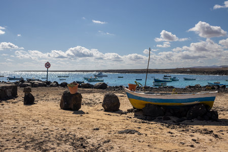 Shiny water of the Atlantic ocean in a bay, during a sunny winter day. Fishing wooden boats. Blue...