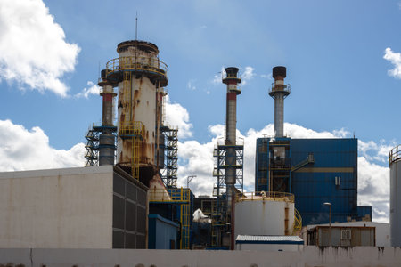 Skuline of the factory and its chimneys in the industrial zone of the capital city. Blue sky with white clouds. Puerto del Rosario, Fuerteventura, Canary Islands, Spain.の写真素材