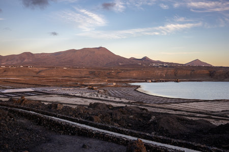 Photogenic industry: salt pans on the coast of the Atlantic ocean. Traditional way to extract the salt from the sea water. Blue sky with some clouds. Salinas de Janubio, Lanzarote, Canary Islands, Spain.の写真素材