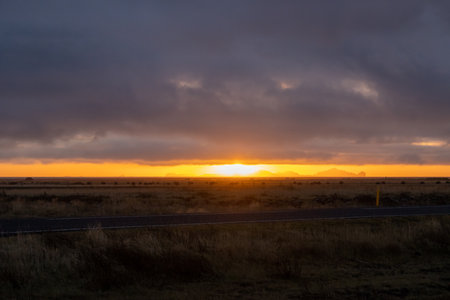 Intense autumn rainy clouds. Visible sun on the horizon during the sunset. South Icelandの写真素材