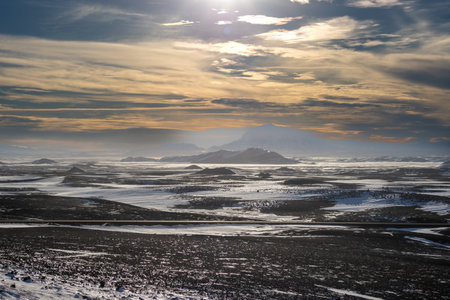 Area, where the geysers are appearing very often and the geothermal activity is viisble also on the unfrozen lines in the snow. Early sunset in the North-Central part Myvatn, Iceland.の写真素材