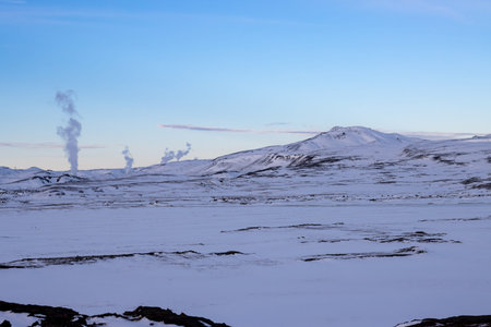 Area, where the geysers are appearing very often and the geothermal activity is viisble also on the unfrozen lines in the snow. Early sunset in the North-Central part Myvatn, Iceland.の写真素材