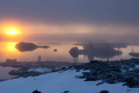 Colorful sunset at the lake. Littlebit of snow on the coast. Sky with clouds in the autumn. Slight fog. Myvatn, North Iceland.の写真素材