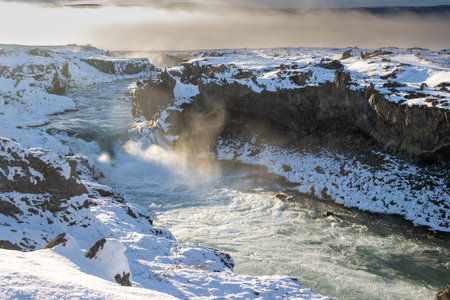 Part of the famous waterfall. Backlight of the winter sun. The air full of steam, spray and fog....