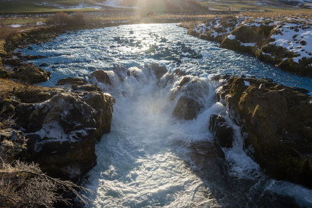 Wild icelandic river with a cascade. White foam and steam. Sunny day in the autumn. Jonasarlundur, Icelandの写真素材