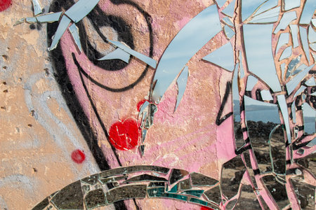 Abandoned simple building. Outer wall covered by graffiti and a mosaic made of pieces of mirror. Lanzarote, Canary Islands, Spain.の写真素材