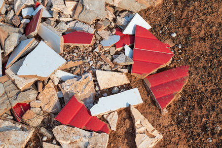 Ceramic red and white tiles broken into small sharp pieces, thrown on the volcanic soil in the nature. Lanzarote, Canary Islands, Spain.の写真素材