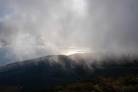 Mountains covered by fresh greenery. Clouds above them during a spring early evening. Risk Calheta,...