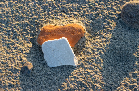 Abstract view on the beach. Dark color of the sand. Washed out stone and brick. Everything with a golden color touch during sunset. Spadafora, Sicily, Italy.の写真素材