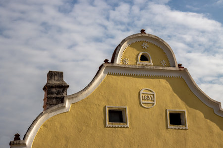 Detail of a historical house built in style peasants baroque in 1831.. Very well preserved building, part of UNESCO World Heritage Sites. Blue sky with white clouds. Holasovice, Czech repbulic.の写真素材