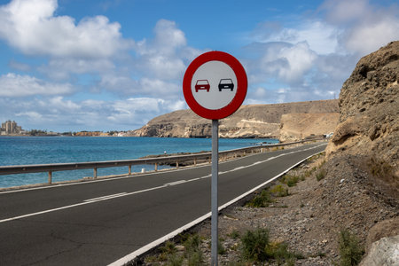 Mountains and road lining the coast on the south. Blue sky with white clouds. Sunny day. Area of Montana de la Arena, Las Palmas, Gran Canaria, Canary Islands, Spain.の写真素材