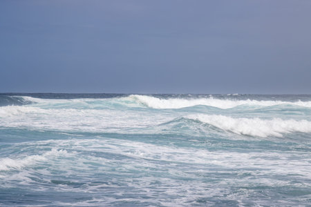Detail of Atlantic ocean waves during a windy winter day. Horizon of the ocean and blue sky. Gula,...