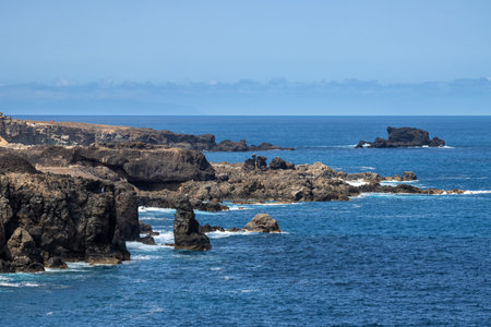 Rocks and cliffs on the coast of Atlantic ocen. Blue sky, sunny day, white clouds. Costa Ayala, Las...