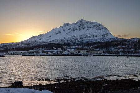 Bay in the late autumn. Country covered by snow. Mountain and sky during short sunrise of an arctic day.の写真素材