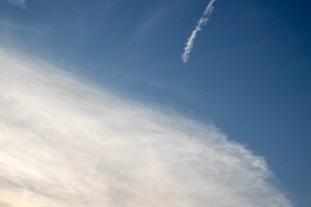 Abstract view on the blue sky with a diagonal white cloud and a part of a trail. Island Corfu...