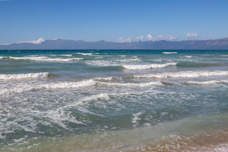 Ionian sea with dramatic waves during a late summer day. Albanian mountains in the background. Blue sky with white clouds. North of the island Corfu (Korfu), Acharavi, Greece.の写真素材