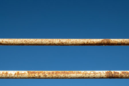 Contrast of a weathered rusted railing of a pier and brightness of a blue sky in the background.の写真素材