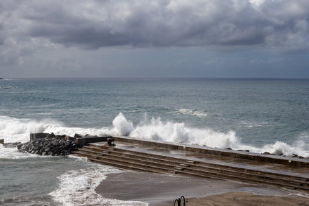 Wild coast of Atlantic ocean on the northern part of the island. Natural rocky and partly artificial places to enjoy the water in the calm weather. North of Tenerife, Santa Cruz, Canary Islands, Spain.の写真素材
